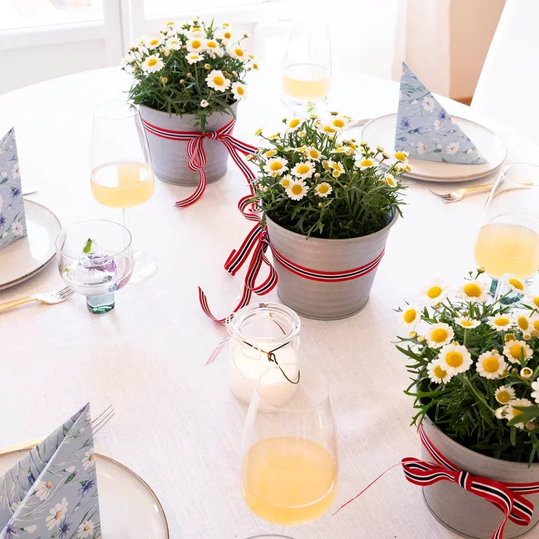Decorate the table for May 17th with flowers and decorations in red, white, and blue