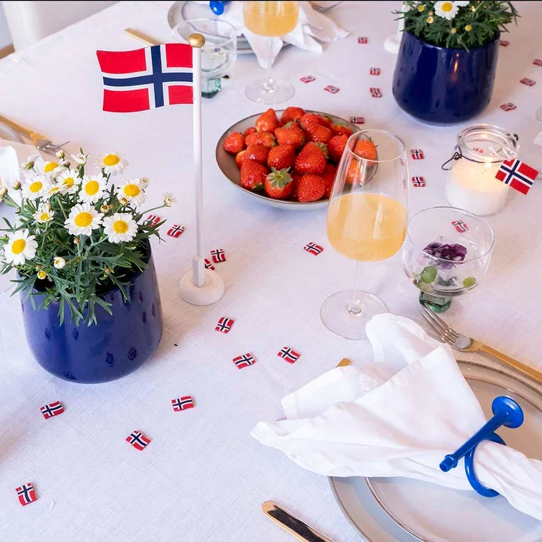 Decorate the table for May 17th with flowers and decorations in red, white, and blue